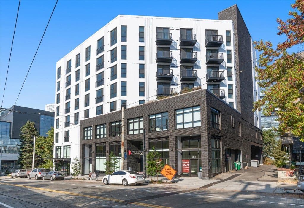 A modern multi-story building with a mix of white and dark facades.